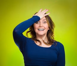 Closeup portrait excited young middle aged woman placing hand on head, palm on face gesture in duh moment, isolated green background. Human emotion facial expression feelings, body language, reaction