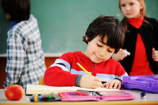 Cute boy concentrating on working on school work.