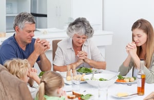 Family praying together as part of their home church